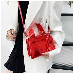 Détail du sac à main rouge métallisé brillant avec bandoulière sur blazer blanc chic