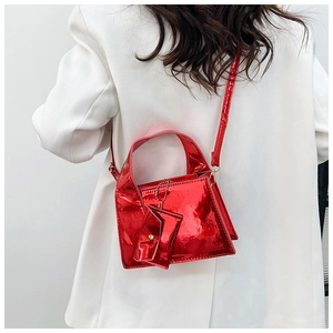 Petit sac à main carré rouge brillant avec charm sur une tenue de blazer blanc