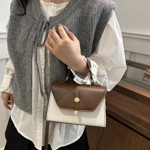 Brown and white leather crossbody bag with golden buckle and top handle for women