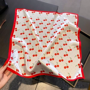 Silk cherry print neck scarf with red border edge showing luxurious satin texture