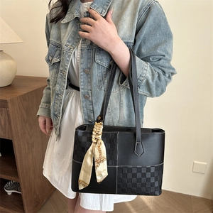 Elegant black tote bag with checkerboard patchwork and silk scarf on top handle