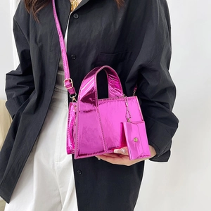 Mini sac à main fuchsia brillant avec bandoulière et pendentif sur modèle