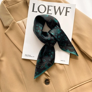 Elegant emerald green silk scarf with black vintage paisley pattern on khaki blazer