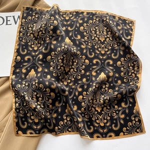 Detail of a luxurious black and gold baroque pattern silk scarf with satin luster