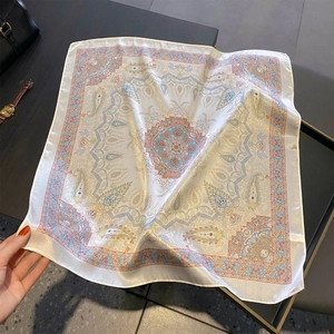 Close-up of lightweight paisley 100% silk neck scarf on a stylish grey background