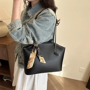 Chic black tote bag with decorative scarf and knotted handle for a casual trendy look