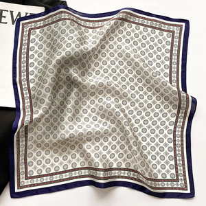 Détail d'un carré de soie avec motifs géométriques et bordures cousues bleu marine