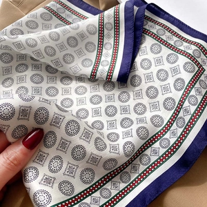 Détail d'un foulard carré en satin de soie avec motif mandala et bordure marine