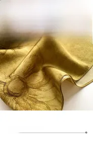 Détail macro des bords cousus et de la texture du tissu en soie florale de l'écharpe