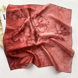 Détail d'un foulard en soie rouge avec un grand motif de tournesol peint à la main