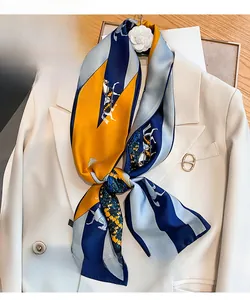Detail of silk narrow scarf with horse print and color-block pattern on cream blazer