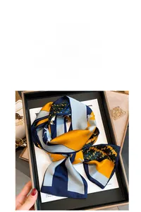 Detail of vintage horse pattern silk scarf in navy and yellow with satin texture