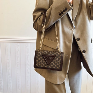 Schicke Monogramm Umhängetasche mit goldener Kette getragen zu eleganter Kleidung