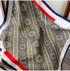 Detalle de un pañuelo de seda cuadrado con motivos paisley y bordes geométricos