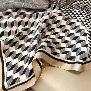 Detailed view of elegant geometric diamond pattern silk scarf with golden satin border