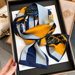Detail of vintage horse pattern silk scarf with vibrant yellow and navy blue contrast colors