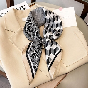 Close-up of geometric pattern silk scarf styled as a bow on a beige blazer lapel