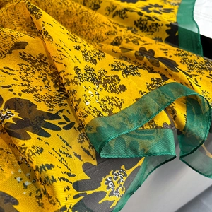 Detail of yellow oil painting silk scarf with black floral prints and green silk edges