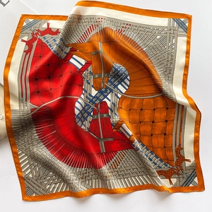 Detail of silk square scarf featuring equestrian patterns with horses and bridles