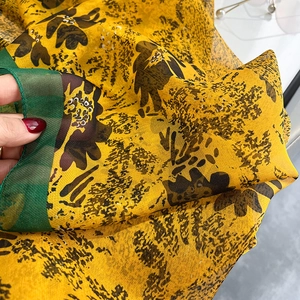 Close-up of lightweight yellow and green oil painting silk scarf with sheer texture