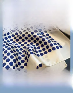 Detail view of polka dot silk scarf featuring fine rolled edges and high-quality printing