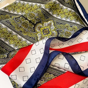 Detalle de bufanda de seda con motivos paisley y formas geométricas en rojo y azul vibrante