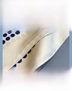 Detailed close-up of the fine stitching and rolled edges on a silk polka dot scarf