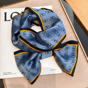 Sciarpa di seta blu con farfalle nere e bordo a contrasto annodata a fiocco
