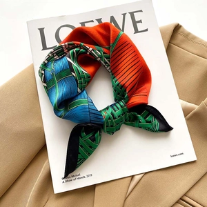 Detail of a patterned 53cm silk square scarf with geometric weave in orange and green