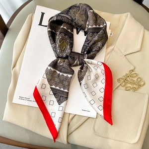 Elegante pañuelo de seda francés con borde rojo y motivos paisley sobre un blazer