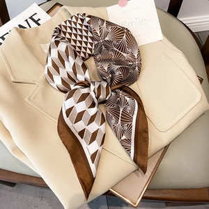 Detail of silk-feel square scarf with geometric patterns tied on a beige blazer lapel