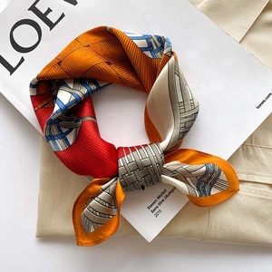 Close-up of a 53cm silk square scarf featuring geometric horse weave patterns in orange