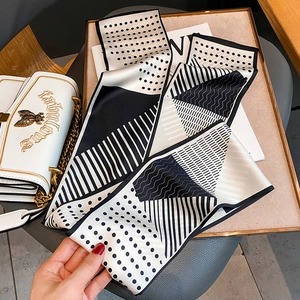Sciarpa sottile a pois e strisce su vassoio dorato con accessori di tendenza
