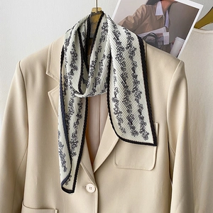 Elegant pleated floral scarf with vintage pattern on a beige blazer for stylish outfit
