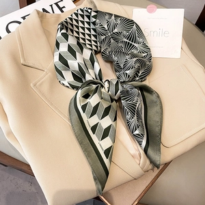 Elegant emerald green geometric silk scarf with checkered pattern on a beige suit