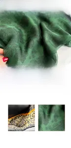 Detail of emerald green silk scarf featuring black floral patterns and leopard print edge
