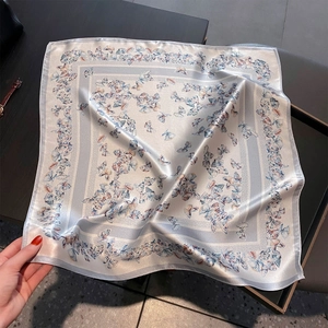 Vue détaillée d'un grand foulard carré en soie avec imprimé papillon bleu et lustre