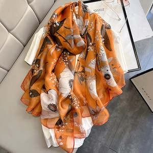 Large orange floral silk scarf with bee print and elegant rolled edges for beach or resort