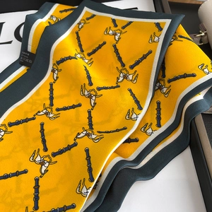 Close-up of yellow vintage silk scarf with horse harness pattern and fine stitching