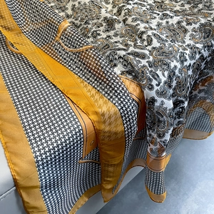 Macro detail of houndstooth and paisley silk scarf with elegant yellow and black patterns