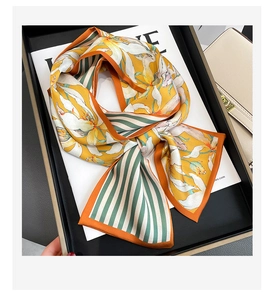 Détail d'un foulard floral en soie jaune avec un nœud élégant et des motifs à rayures
