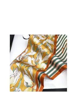 Détail d'un foulard soyeux avec motifs floraux de gingembre et bords rayés