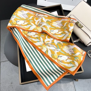 Détail d'un foulard en soie jaune avec lys blancs et pointes rayées vert
