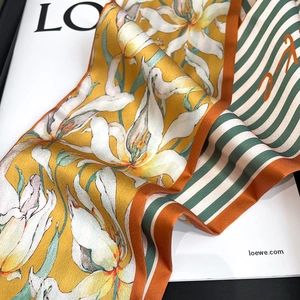 Gros plan détaillé d'un foulard en soie avec motifs de lys et bordures rayées