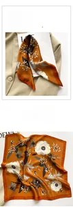 Detail of floral silk scarf with orange background and hand-drawn white flowers