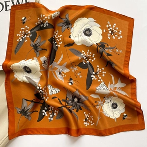 Detail of burnt orange silk square scarf with floral prints and insect motifs