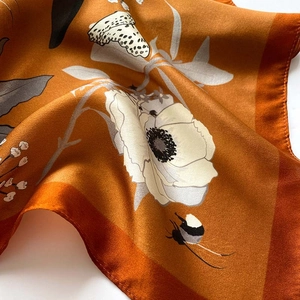 Close-up of floral silk scarf with caramel orange satin finish and vintage bee prints