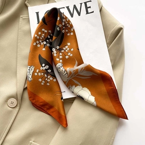 Floral silk square scarf in warm orange with mushroom prints on a beige blazer