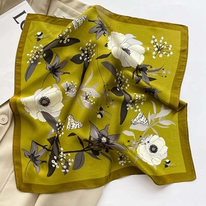 Close-up of a floral silk scarf draped over a beige suit with butterfly patterns