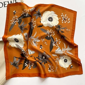 Orange silk square scarf featuring elegant floral patterns and butterfly motifs